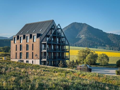a building on top of a hill next to a field at Demänová Rezort in Liptovský Mikuláš