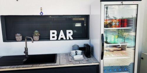 a bar sign on a window above a kitchen sink at Soulbreeze Bungalows Kos, Haus 1 in Platánion