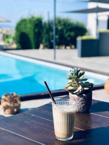 a drink sitting on a table near a swimming pool at Soulbreeze Bungalows Kos, Haus 1 in Platánion
