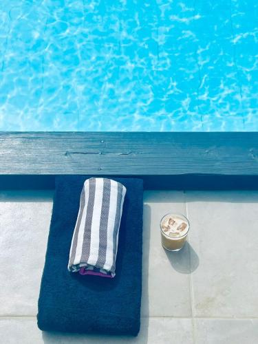 a towel and a bowl next to a swimming pool at Soulbreeze Bungalows Kos, Haus 1 in Platánion