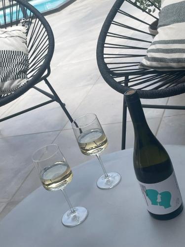 a bottle of wine and two glasses on a table at Soulbreeze Bungalows Kos, Haus 1 in Platánion