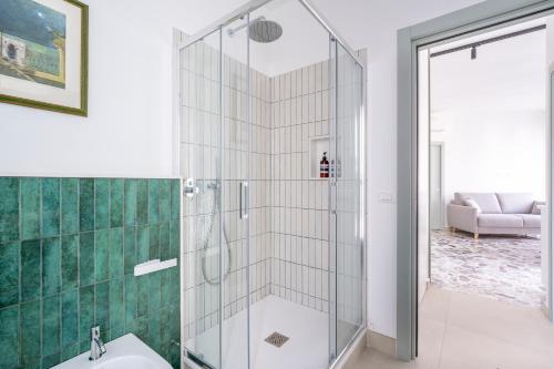 eine Glasdusche im Bad mit Waschbecken in der Unterkunft Eos Serenity Suites in Syrakus