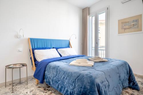 ein Schlafzimmer mit einem blauen Bett mit Handtüchern darauf in der Unterkunft Eos Serenity Suites in Syrakus