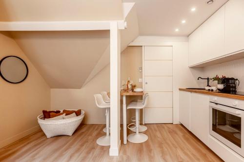 une cuisine avec des armoires blanches et une table et des chaises dans l'établissement A41#Republique # Marais # 1BedRoom # Paris03 # AC, à Paris
