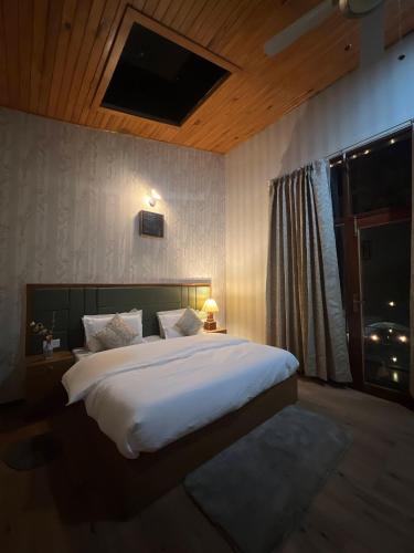 a bedroom with a large white bed and a window at In the woods homestay Lansdowne in Lansdowne