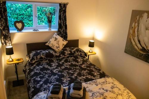 a bedroom with a bed and a window at The Nest Close to York with Hot Tub in Barmby on the Marsh