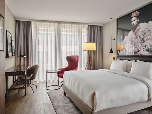 a hotel room with a large bed and a desk at Radisson Collection Hotel, Berlin in Berlin