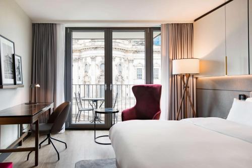 a hotel room with a bed and a desk and a window at Radisson Collection Hotel, Berlin in Berlin