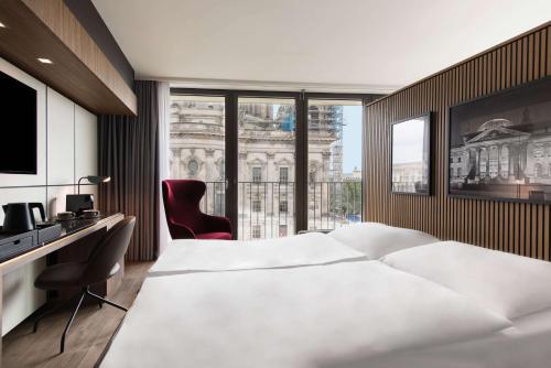 a hotel room with a large bed and a window at Radisson Collection Hotel, Berlin in Berlin