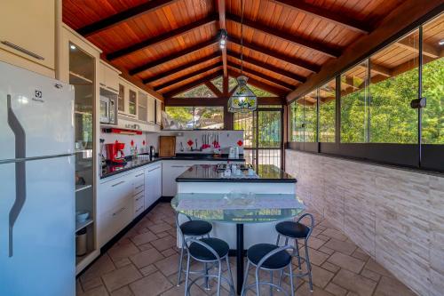 a kitchen with a counter and stools in it at Stúdio Jurerê vista Mar in Florianópolis