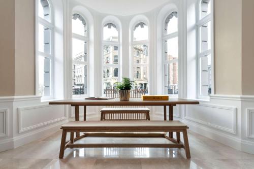 a table in a room with large windows at Radisson Blu Hotel, London Tottenham Court Road in London