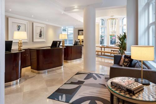 a lobby with a waiting area with a table at Radisson Blu Hotel, London Tottenham Court Road in London