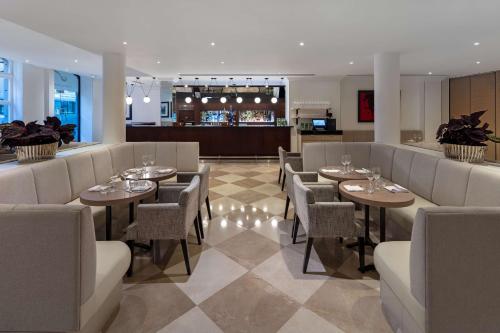 a restaurant with tables and chairs and a bar at Radisson Blu Hotel, London Tottenham Court Road in London