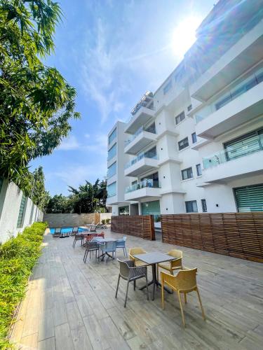 a group of tables and chairs in front of a building at Accra Luxury Apartments at Lul Water in Accra