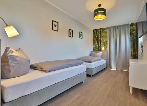 a bedroom with two beds and a window at NEU Villa Heidetraum, 20 Gaeste, Sauna, Pool in Dorfmark