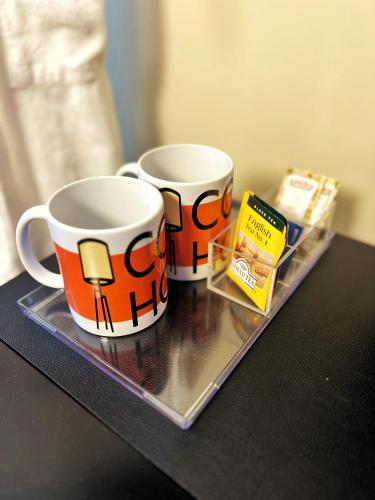 two coffee mugs sitting on a tray on a table at Cozy House in Rio de Janeiro