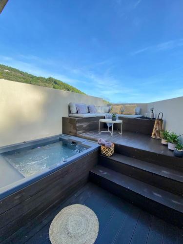 a hot tub sitting on top of a deck at Luxury Suite with a queens double bed stunning sea vews and private Jacuzzi in Megali Ammos
