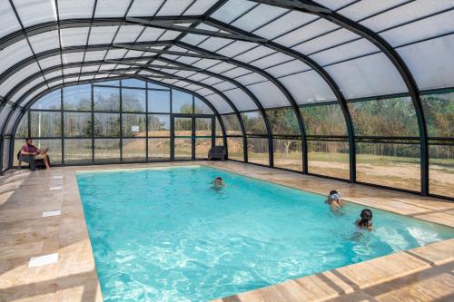 a group of people in a swimming pool in a greenhouse at Camping Paradis Vallée du Lot in Pujols