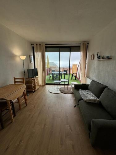 a living room with a couch and a table at Studio chaleureux à Font-Romeu in Font-Romeu