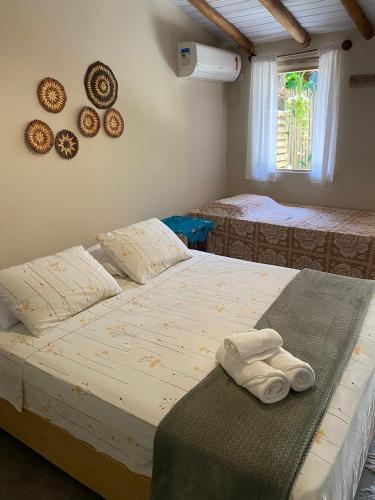 two beds in a room with plates on the wall at Pousada da Vila restaurante in Corumbau