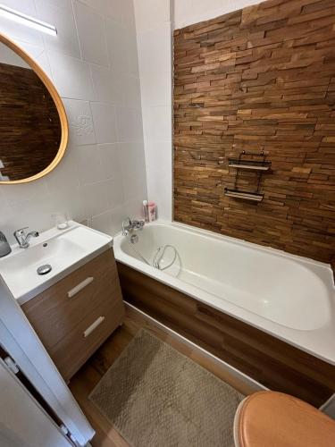 une salle de bain avec une baignoire blanche et un lavabo dans l'établissement Studio chaleureux à Font-Romeu, à Font-Romeu