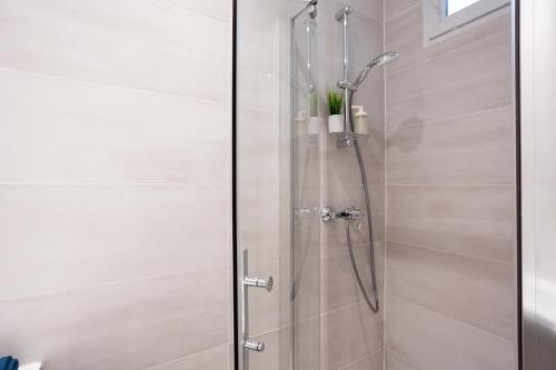 une douche avec une porte vitrée dans une salle de bain dans l'établissement Studio en plein coeur de Paris deuxieme arrondissement Quartier Montergueil Chatelet, à Paris