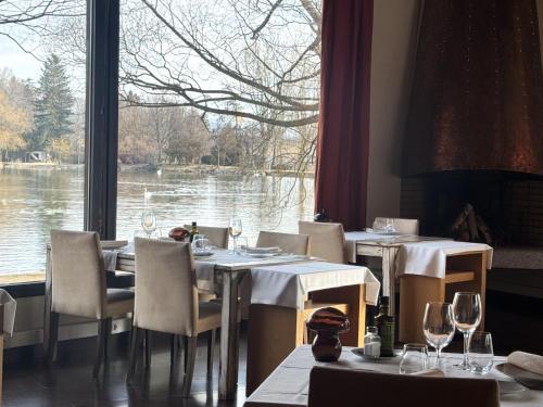 a restaurant with tables and chairs and a large window at Hotel Villa Paulita in Puigcerdà