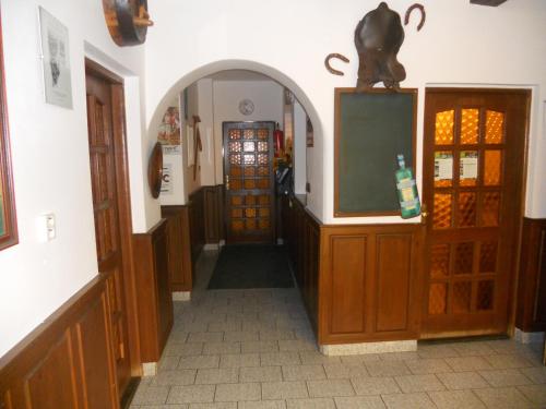 a hallway of a building with a tv and some doors at Penzion Dřevák in Jetřichovice
