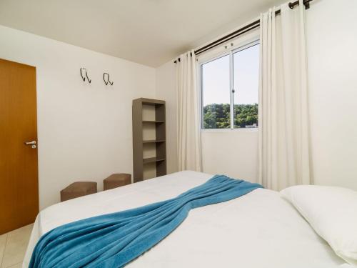 a bedroom with a bed with a blue blanket on it at Apto Vista Mar Conforto e Lazer no Centro PD7324 in Penha