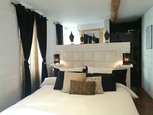 - une chambre avec un lit blanc et des oreillers noirs et blancs dans l'établissement Joli duplex au cœur de Saint Pierre, à Bordeaux