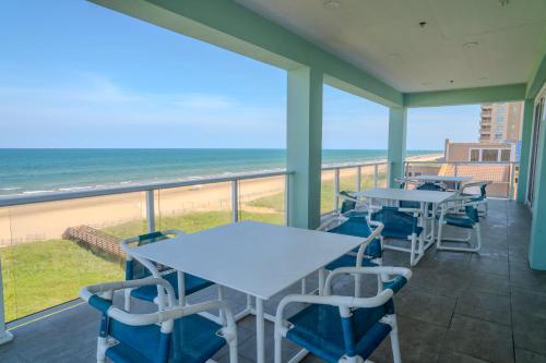 a balcony with tables and chairs and the beach at 5 BEDROOM BEACHFRONT CONDO - 4th Floor in South Padre Island