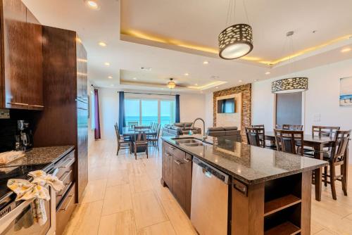 an open kitchen and dining room with tables and chairs at 5 BEDROOM BEACHFRONT CONDO - 4th Floor in South Padre Island