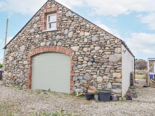 a stone building with a garage at Canning Cottage in Limavady