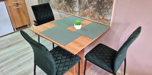 a dining room table with chairs and a plant on it at Apartmani IMW in Zaječar