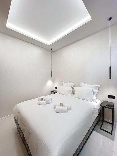 - une chambre blanche avec un grand lit blanc et des oreillers blancs dans l'établissement Luxury Residence - Central Cannes, near Beach & Palais - LRACANNES, à Cannes