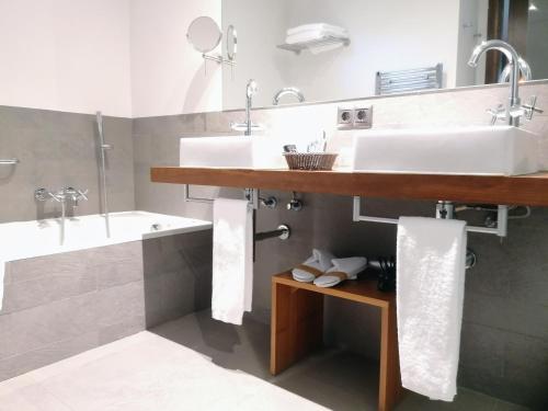 a bathroom with a sink and a tub and a sink at Hotel Villa Paulita in Puigcerdà