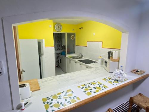 a kitchen with yellow walls and a counter top at Spacious, calm and bright Duplex Apartment in Private Residence ideal for families, beach and golf in Sitio de Calahonda