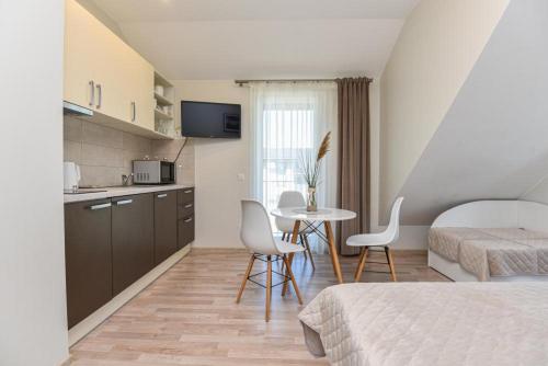 a room with two beds and a table and a kitchen at Vila Dia Palanga in Palanga