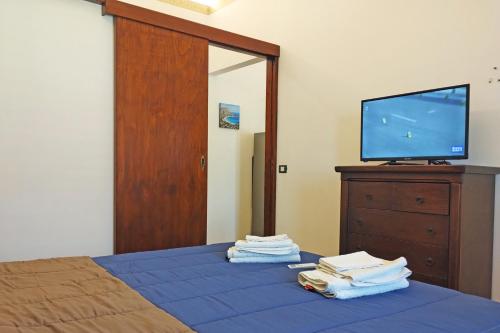 una camera con un letto e una TV su un comò di Porta Carini Residence a Palermo