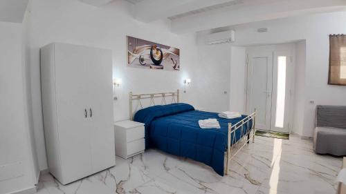 a bedroom with a blue bed in a white room at Clarus Mons in Chiaromonte
