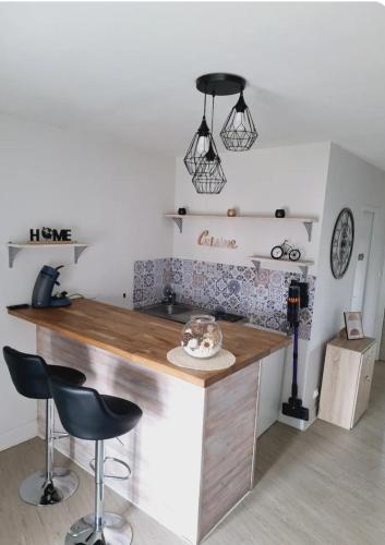 a kitchen with a counter with stools in a room at Charmant F2 centre Issoire avec jolie Vue Sancy et Livradois- WiFi in Issoire