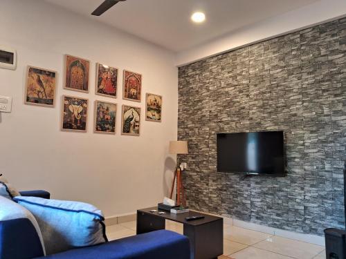 a living room with a tv on a brick wall at Arambol Bliss Hotel Apartments in Arambol