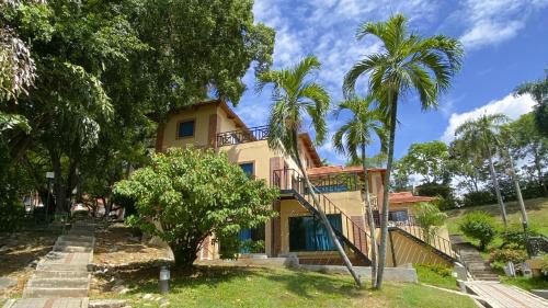 a house with palm trees in front of it at Hotel Girardot Resort by On Vacation in Girardot