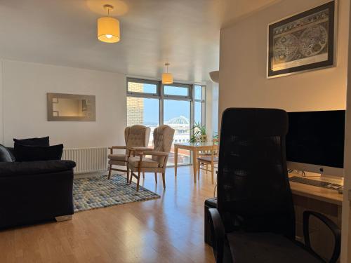a living room with a couch and a table with chairs at Harrow Town Centre Apartment in Harrow