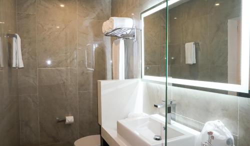 a bathroom with a sink and a shower with a mirror at Hotel Loreto Palmar in Loreto