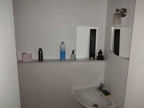 a white bathroom with a sink and a shelf at Maison 2 faces Argeles Centre Ville in Argelès-sur-Mer