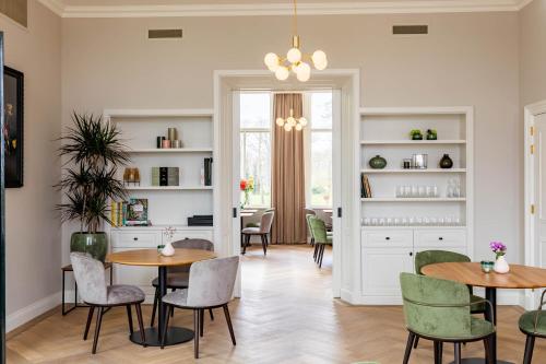 a dining room with two tables and chairs at Hotel Flora Batava in Breukelen