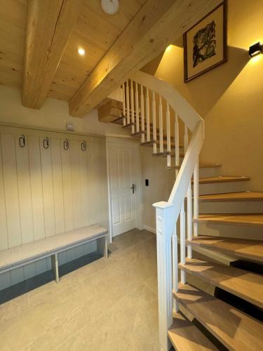 a staircase in a room with a bench and a stair case at Fachwerkhuus in Göhren-Lebbin