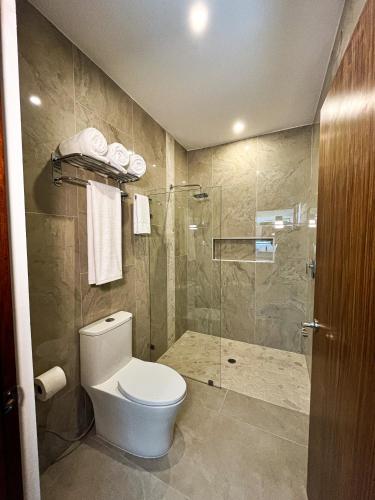 a bathroom with a toilet and a glass shower at Hotel Loreto Palmar in Loreto