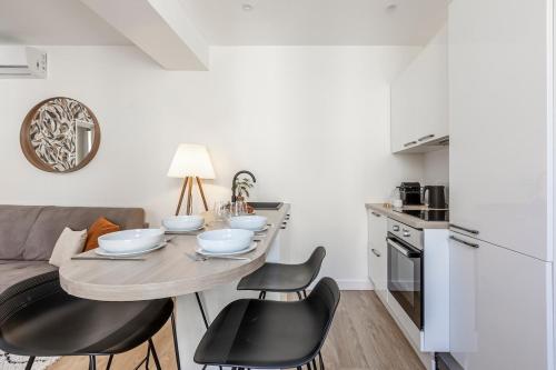 une cuisine avec une table et des chaises dans une pièce dans l'établissement B31#République#Marais#1BedRoom#Paris03#Air conditioning, à Paris